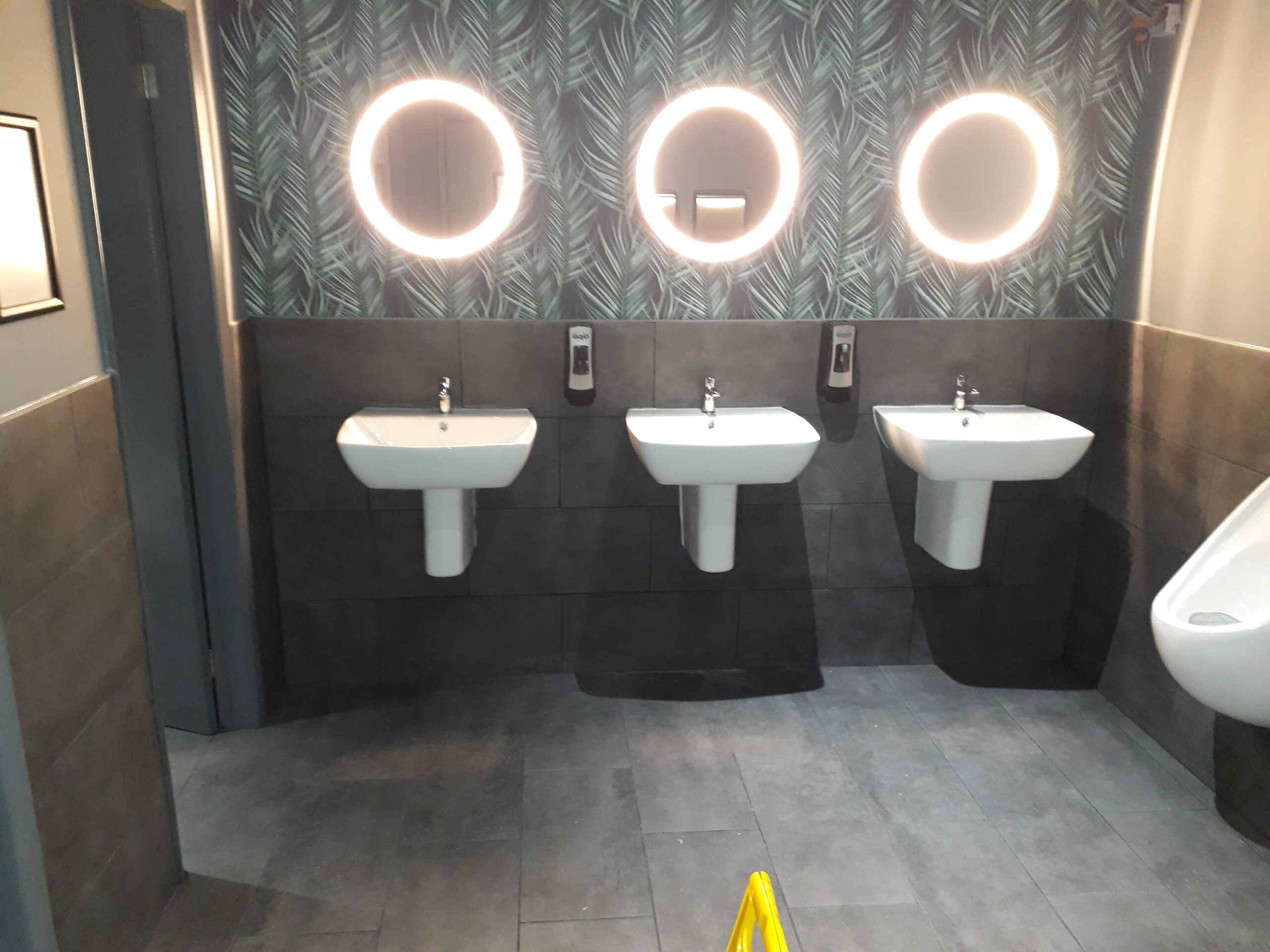 three basins and mirrors on a small comerrcial bathroom