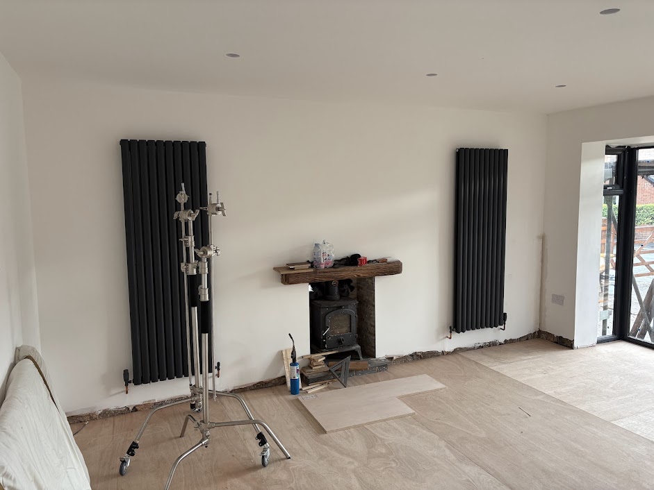 " x designer radiators evenly spaced beside a stove